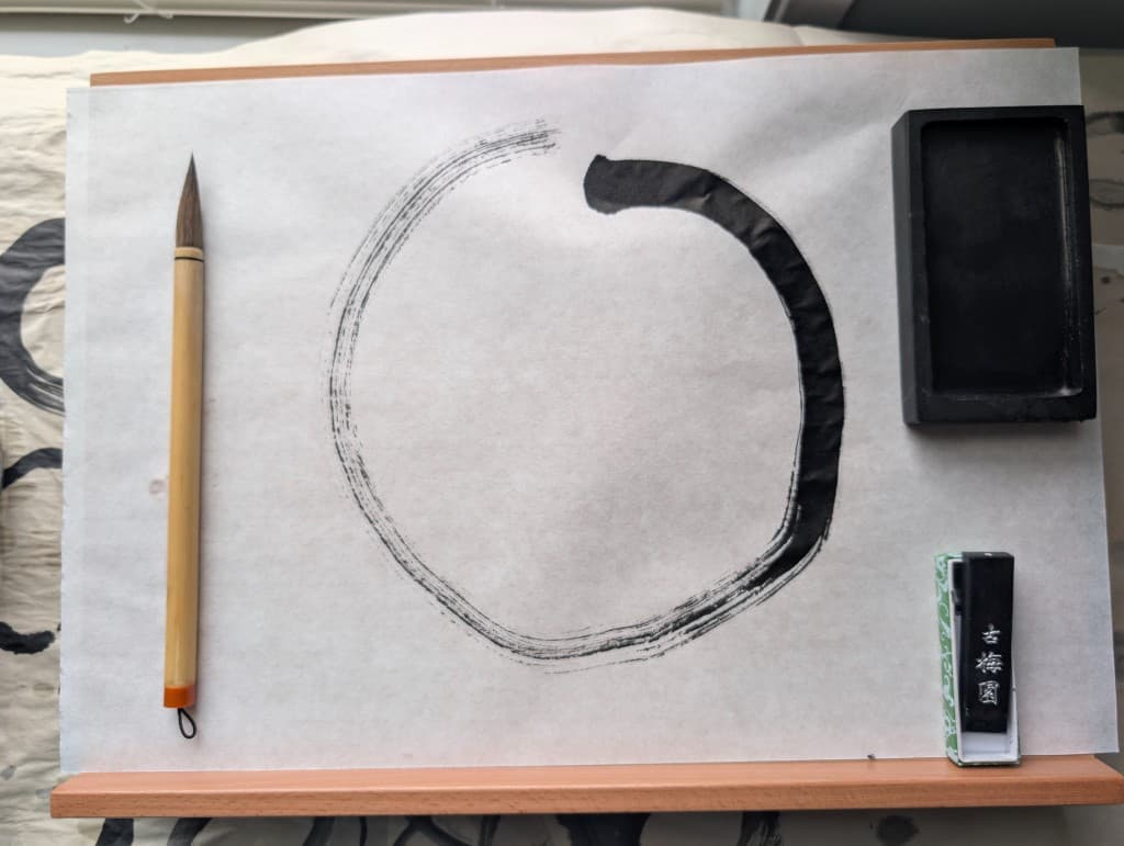 Close-up enso painting with brush and ink tray